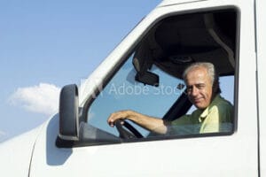 een koerier die met een lach achter het stuur zit